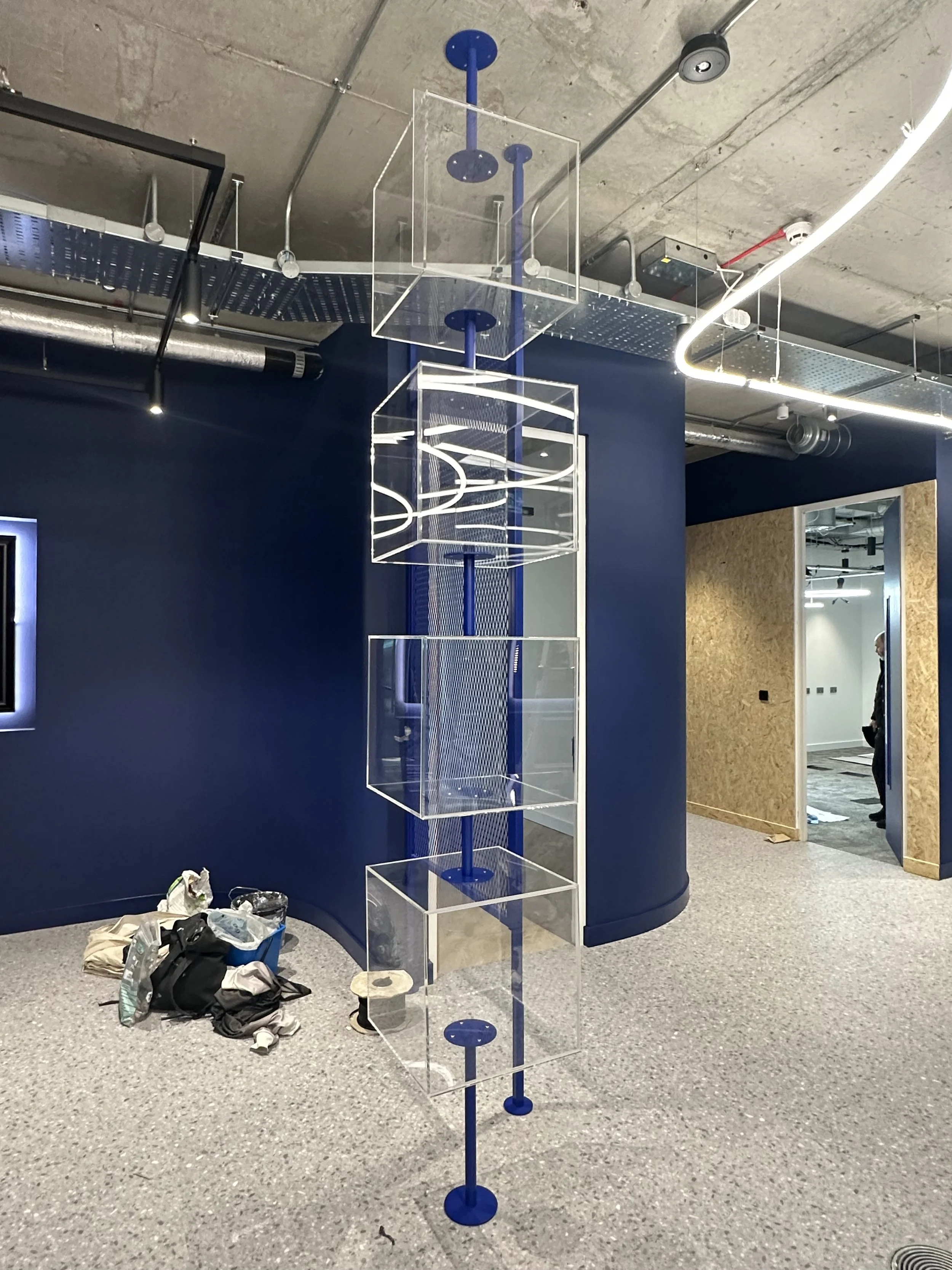 acrylic clear display boxes on metal pole in office.