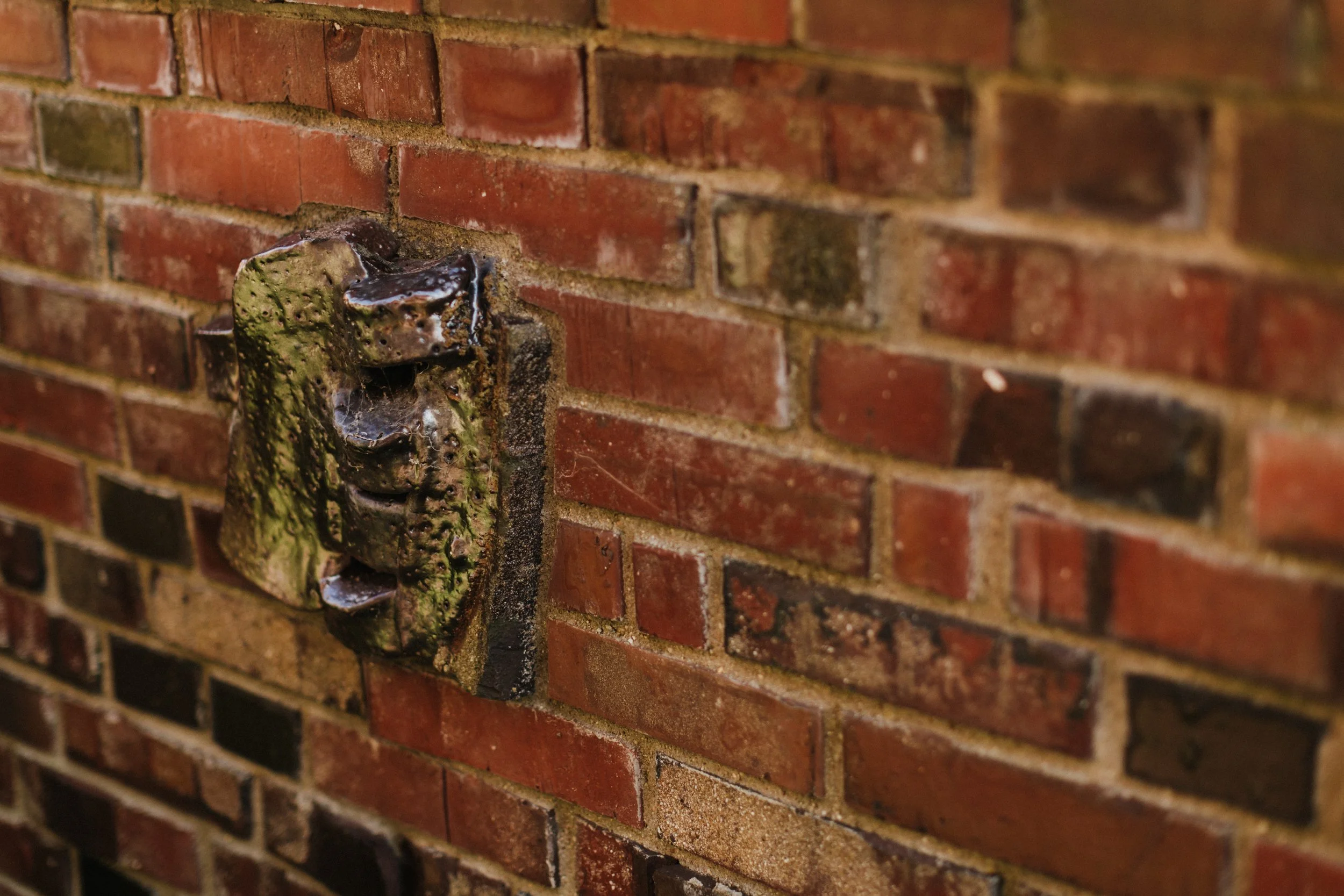 Rostiges Wasserhahndel an einer roten Backsteinwand