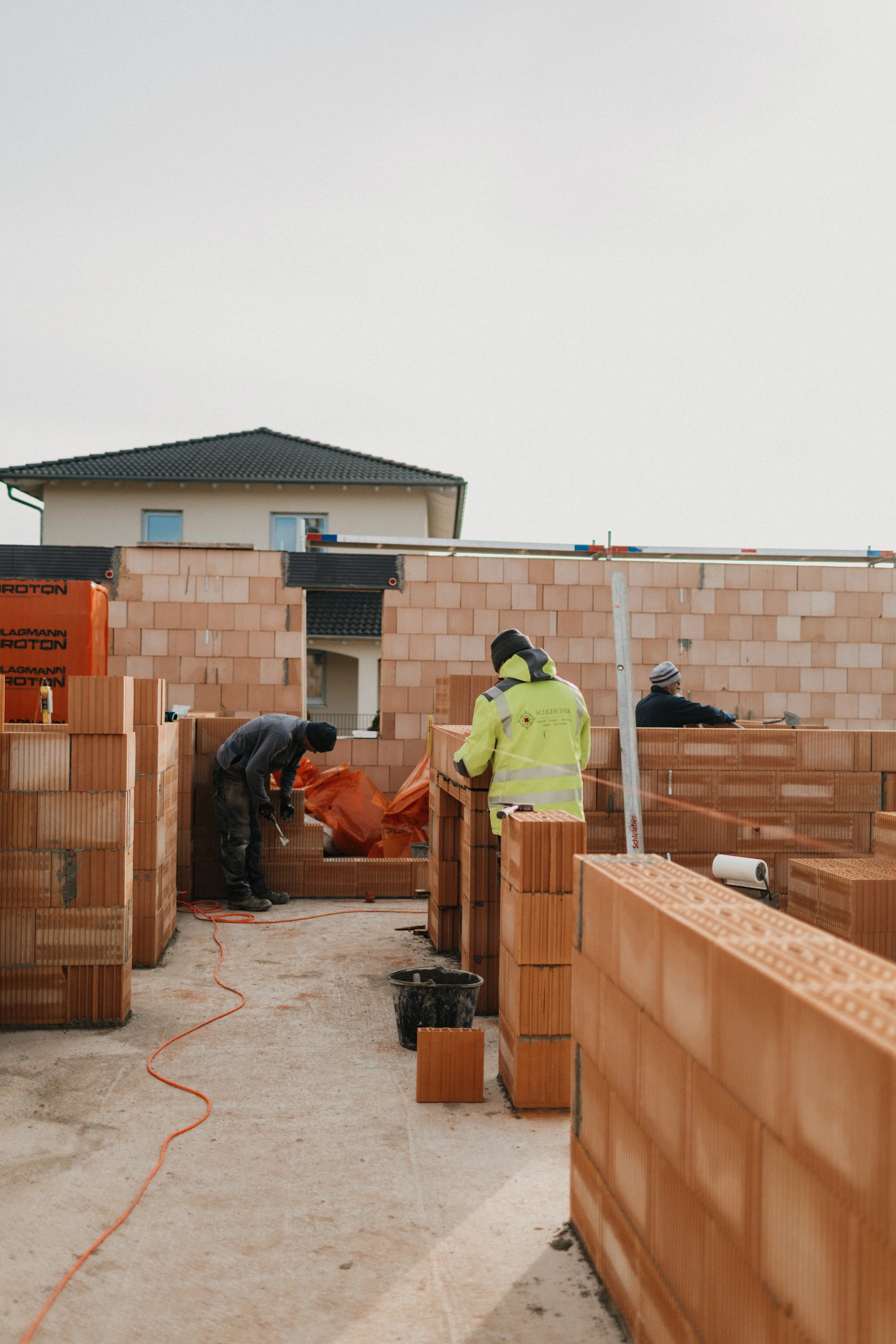Bauarbeiter beim Mauern eines Gebäudes auf einer Baustelle.