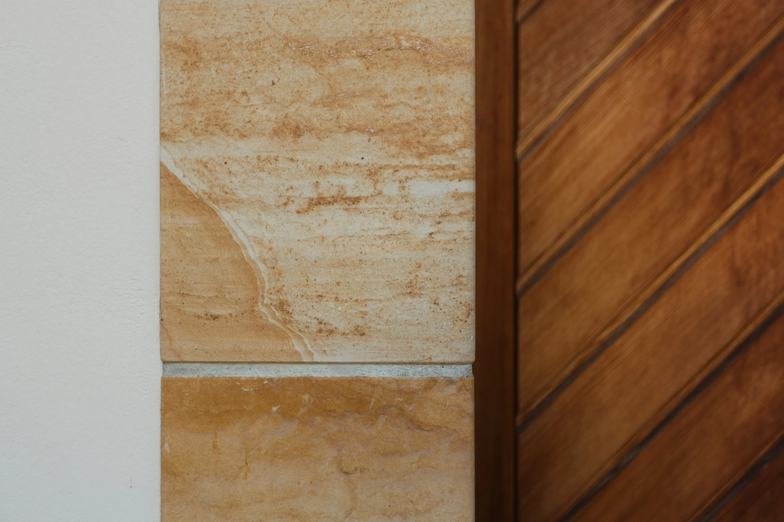 Nahaufnahme von Wandfliesen und Holzpaneelen, unterschiedliches Material und Textur