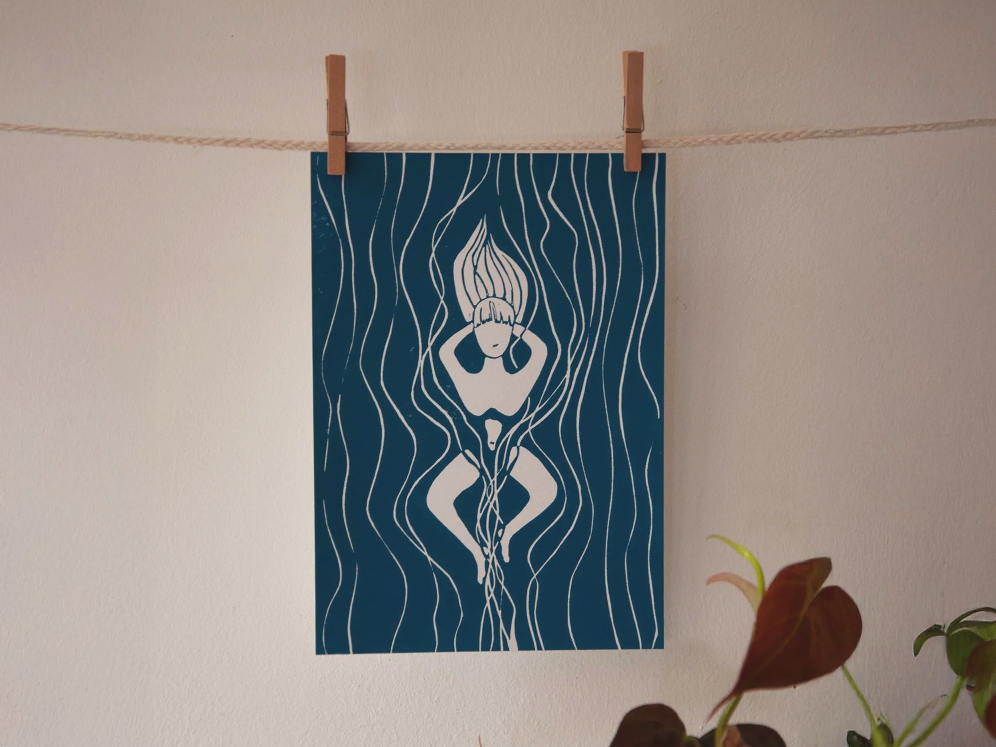 dunkelblauer Linoldruck einer Frau, die vergnügt im Wasser liegt.