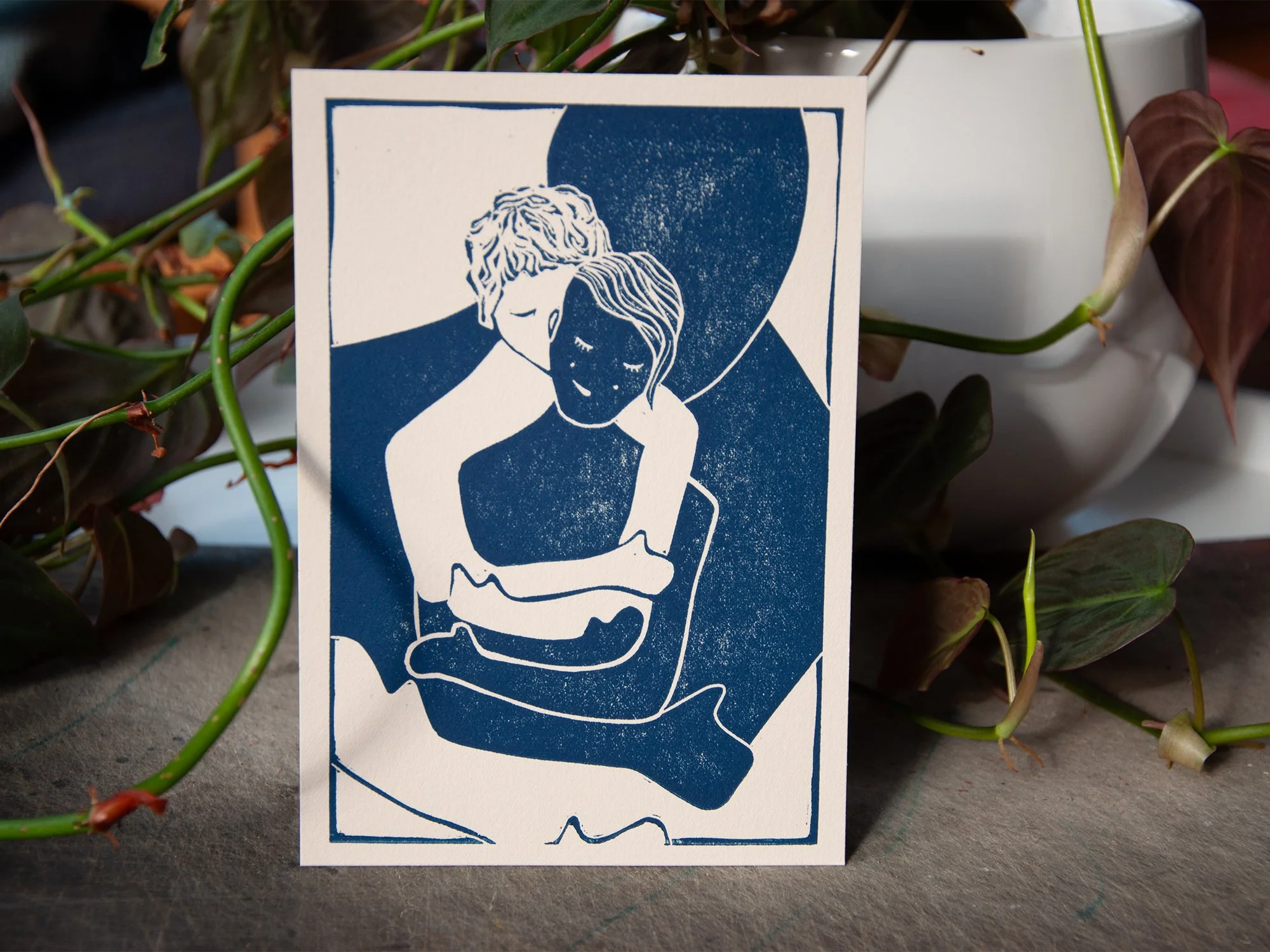 Linolschnitt zweier Menschen oder eines Paares, welches sich fürsorglich umarmt