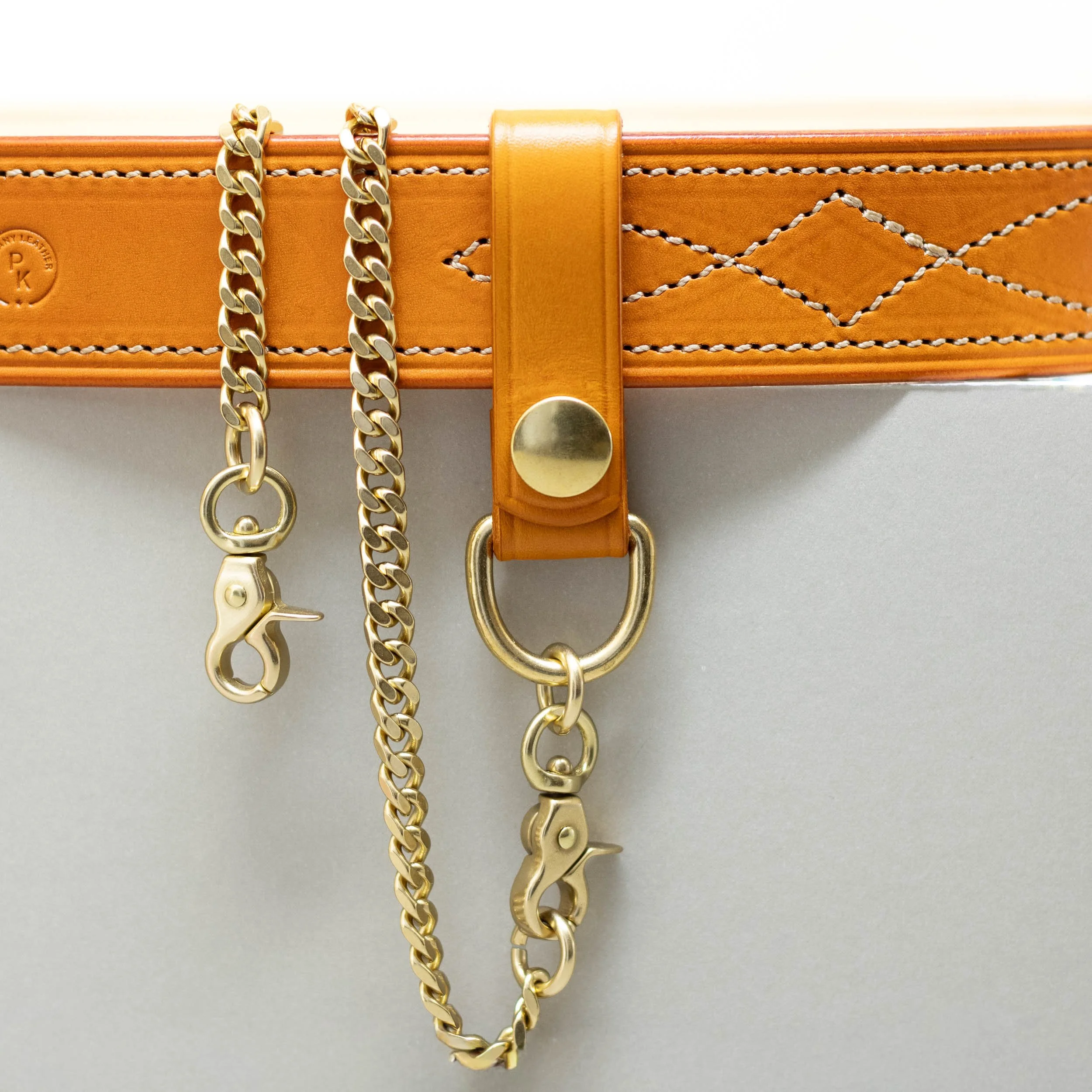 Orange leather belt loop with press stud and brass chain and clip
