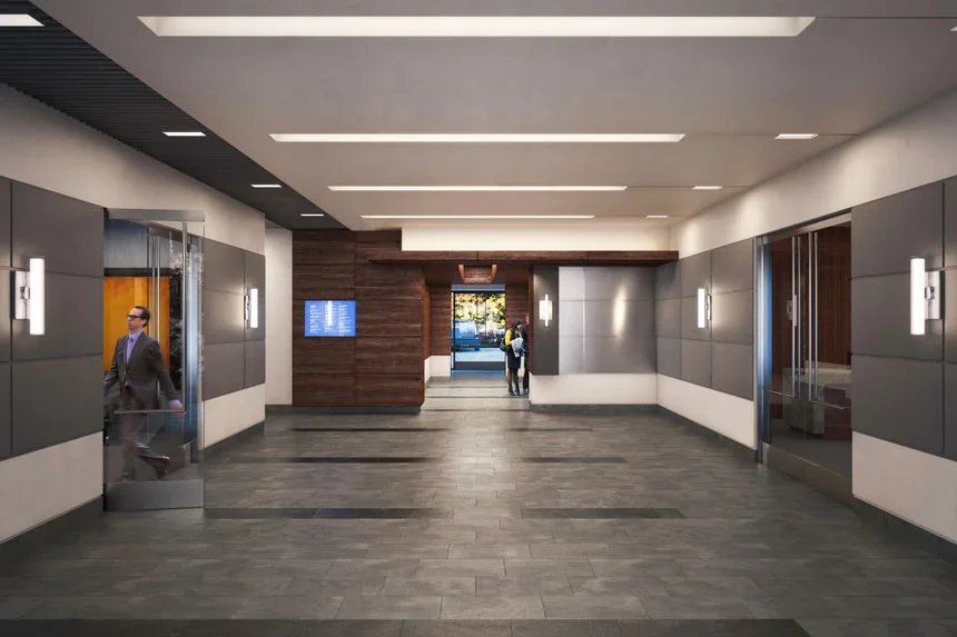 Modern indoor lobby with elevators, wood accents, and people walking.