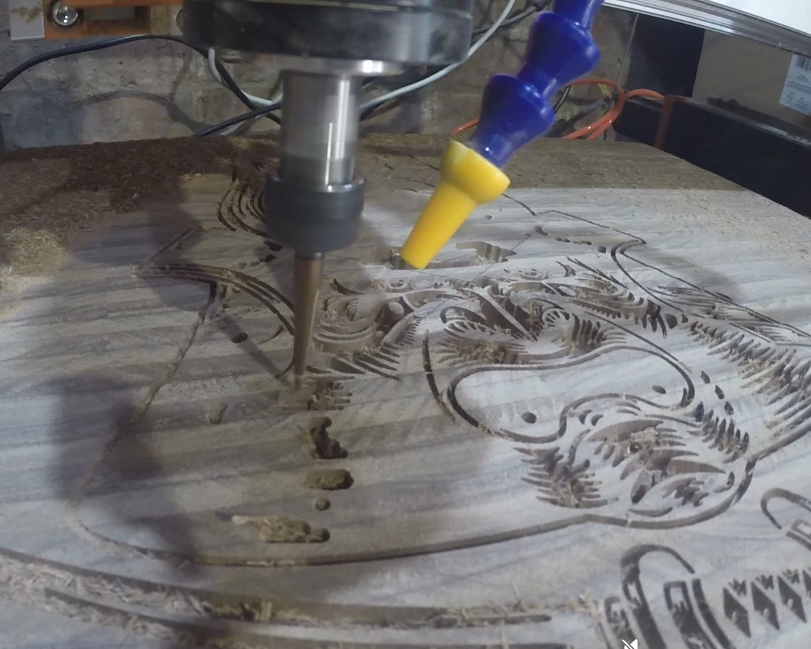 A CNC machine carving a detailed design into a piece of wood.