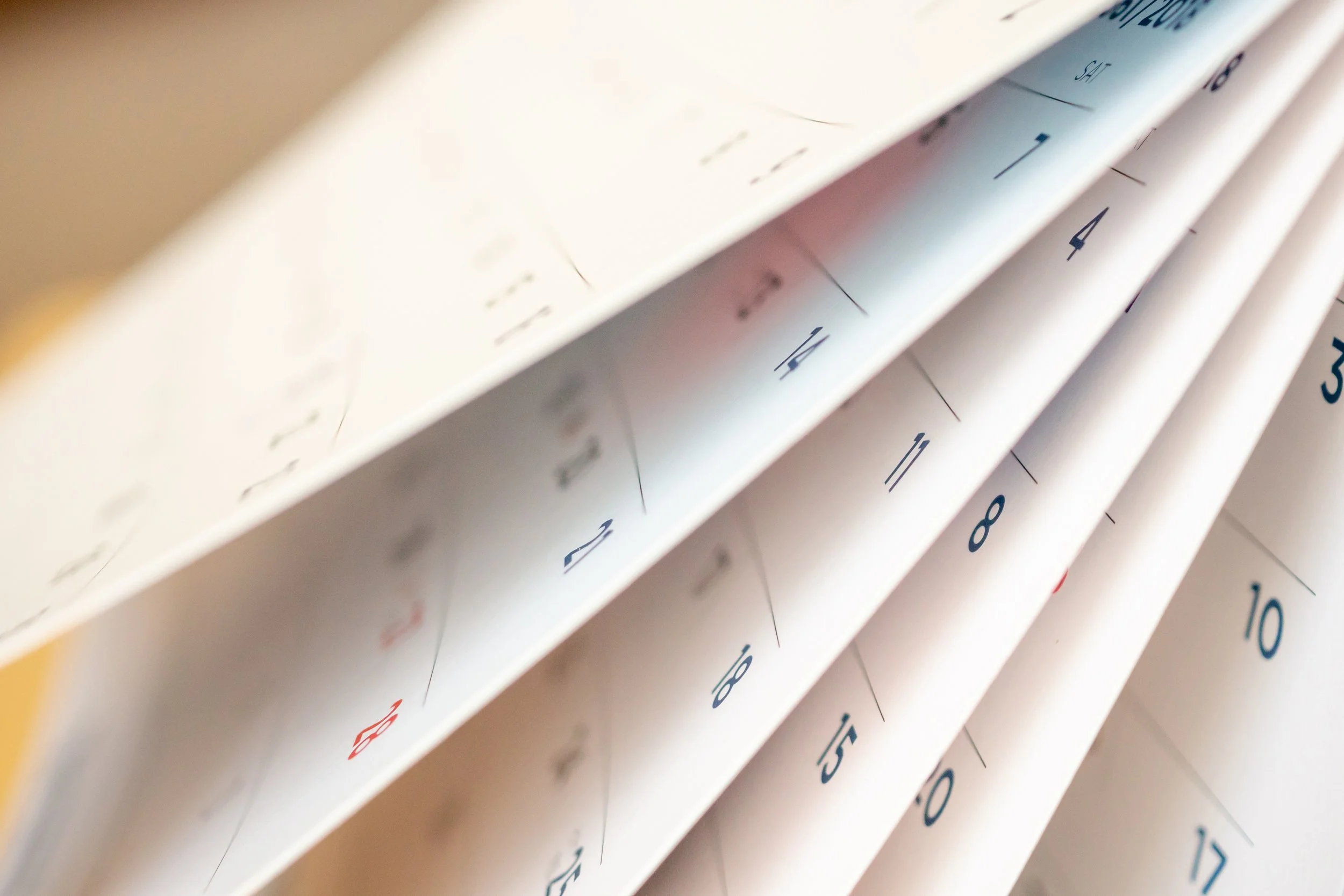 Un calendrier avec des pages tournées, montrant les dates 1 à 17, vues en angle