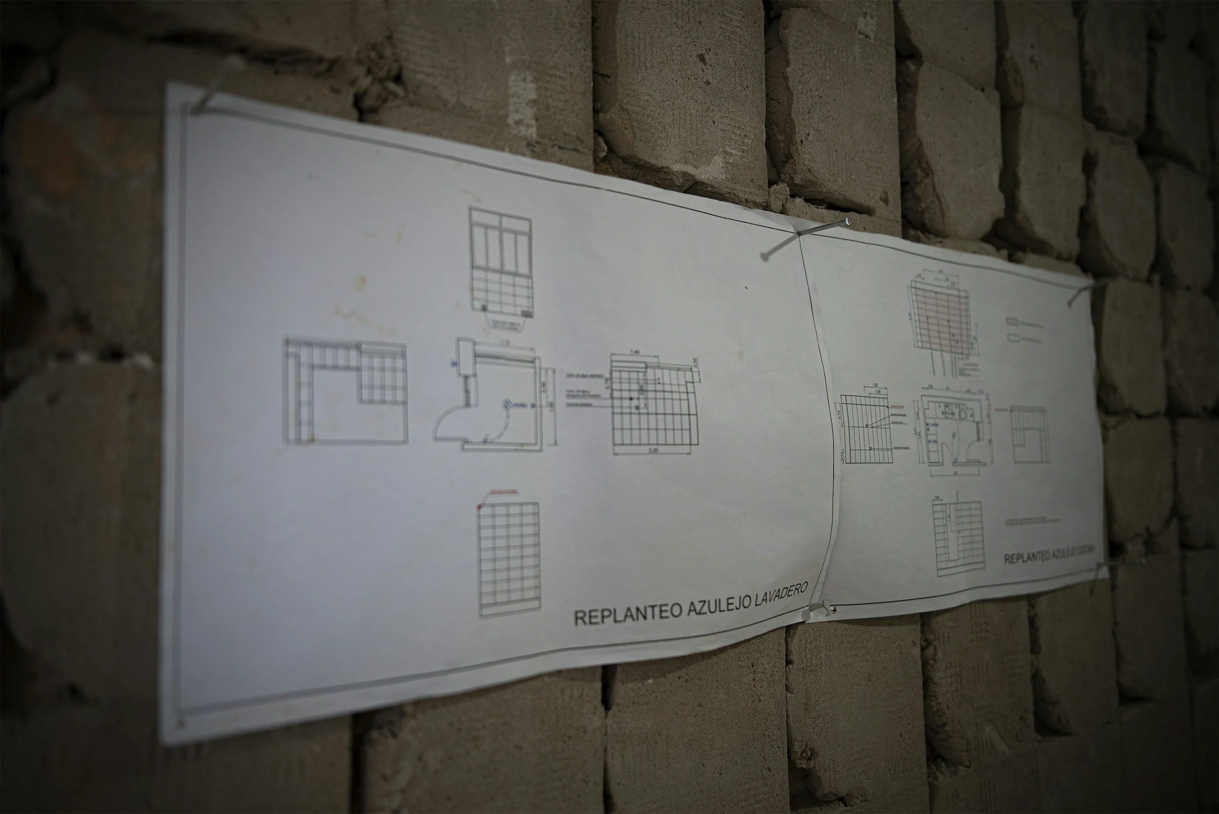 Technical construction drawings pinned to a brick wall, representing MSI Property Group’s refurbishment and building partners.