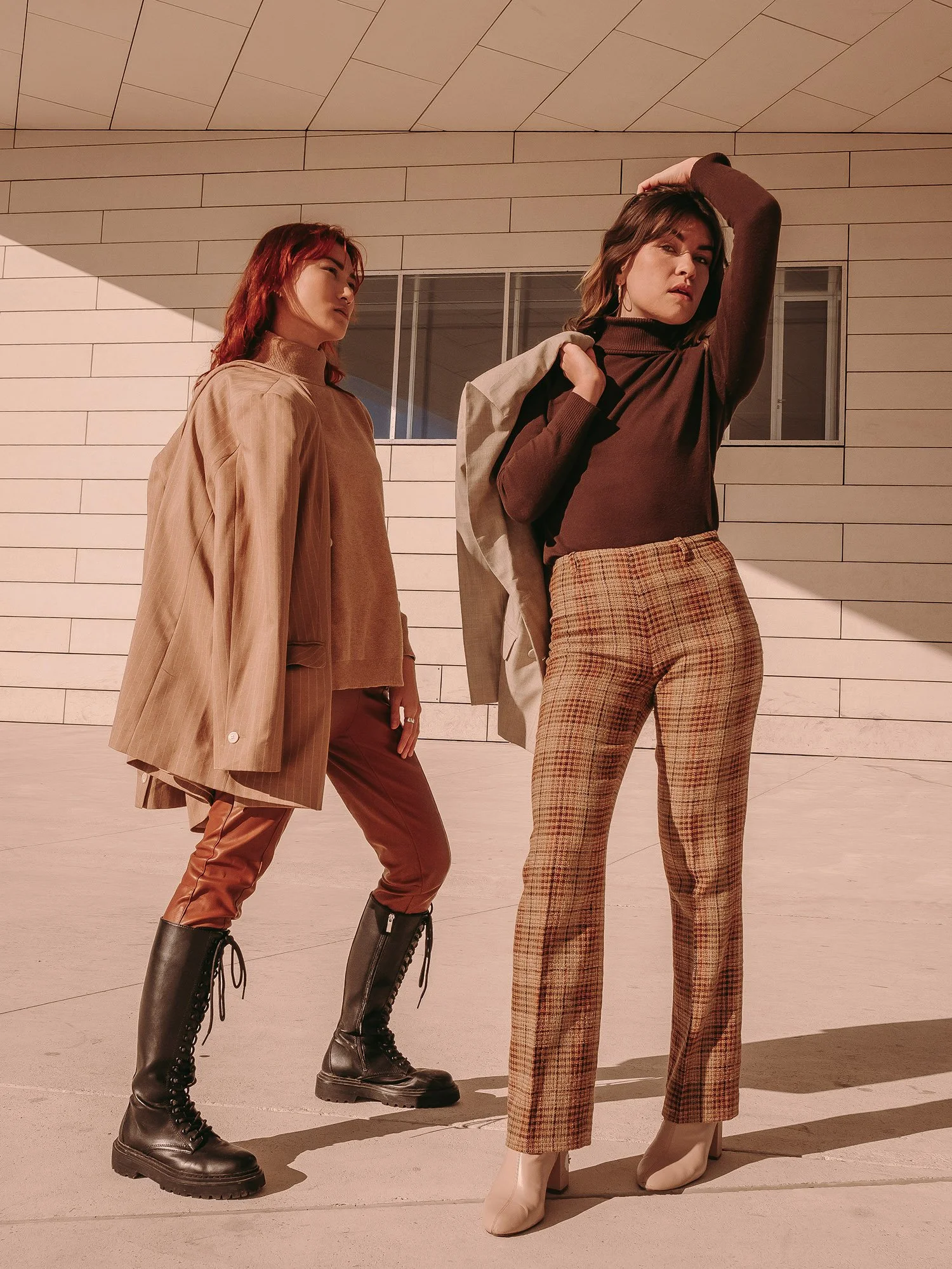 Trois femmes posant devant un mur beige avec des vêtements à la mode et des chaussures tendance.
