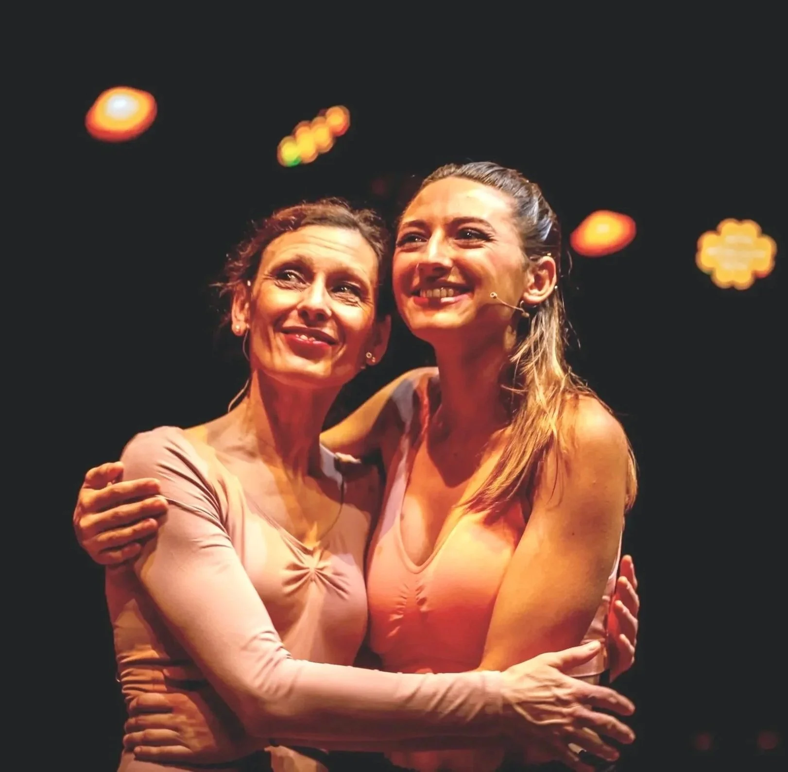 Grupo de personas en vestimentas tradicionales realizando una danza o actuación en un escenario.