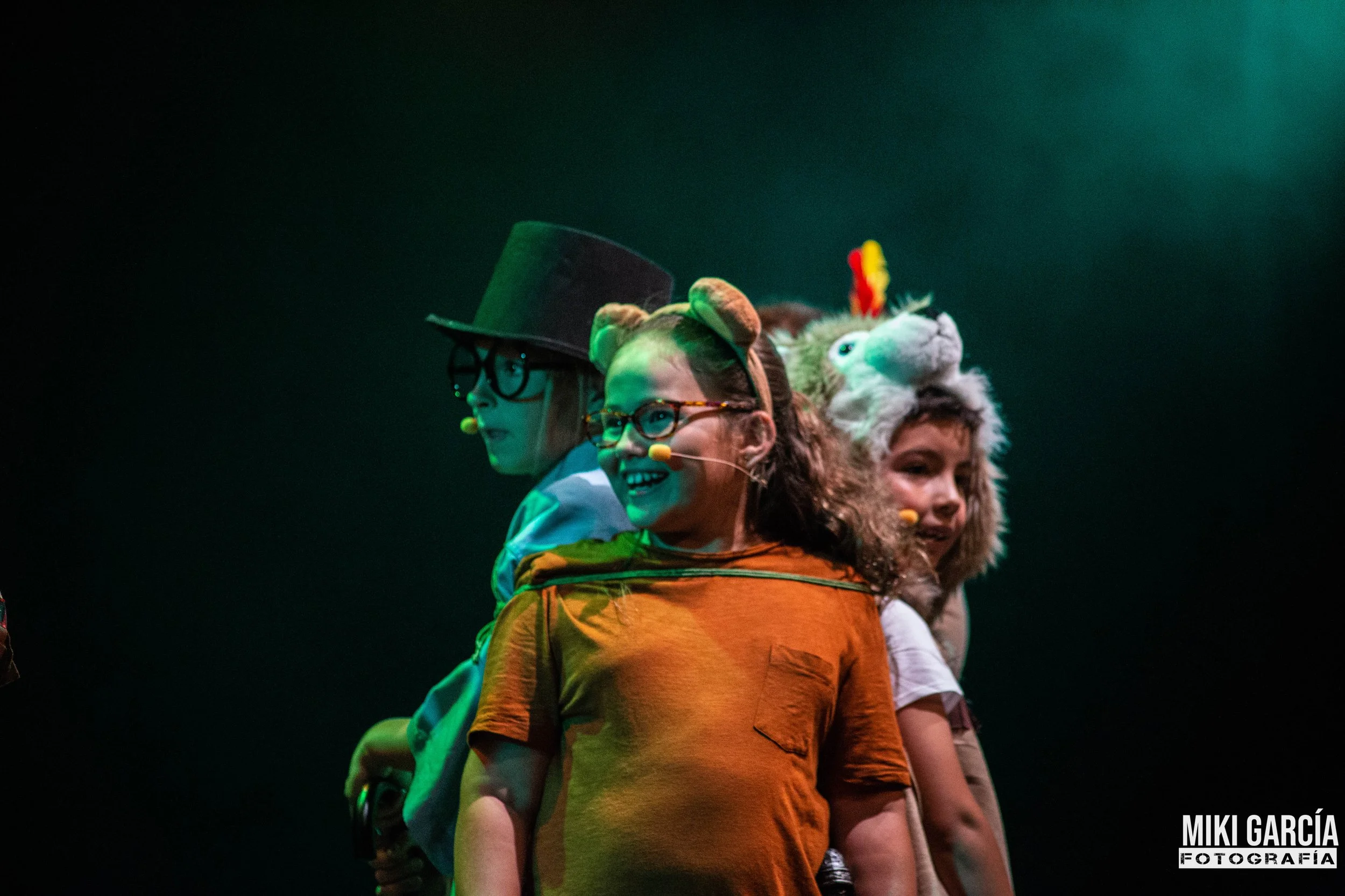 Niños disfrazados en un escenario con vestuario de personajes de animales y personajes creativos.