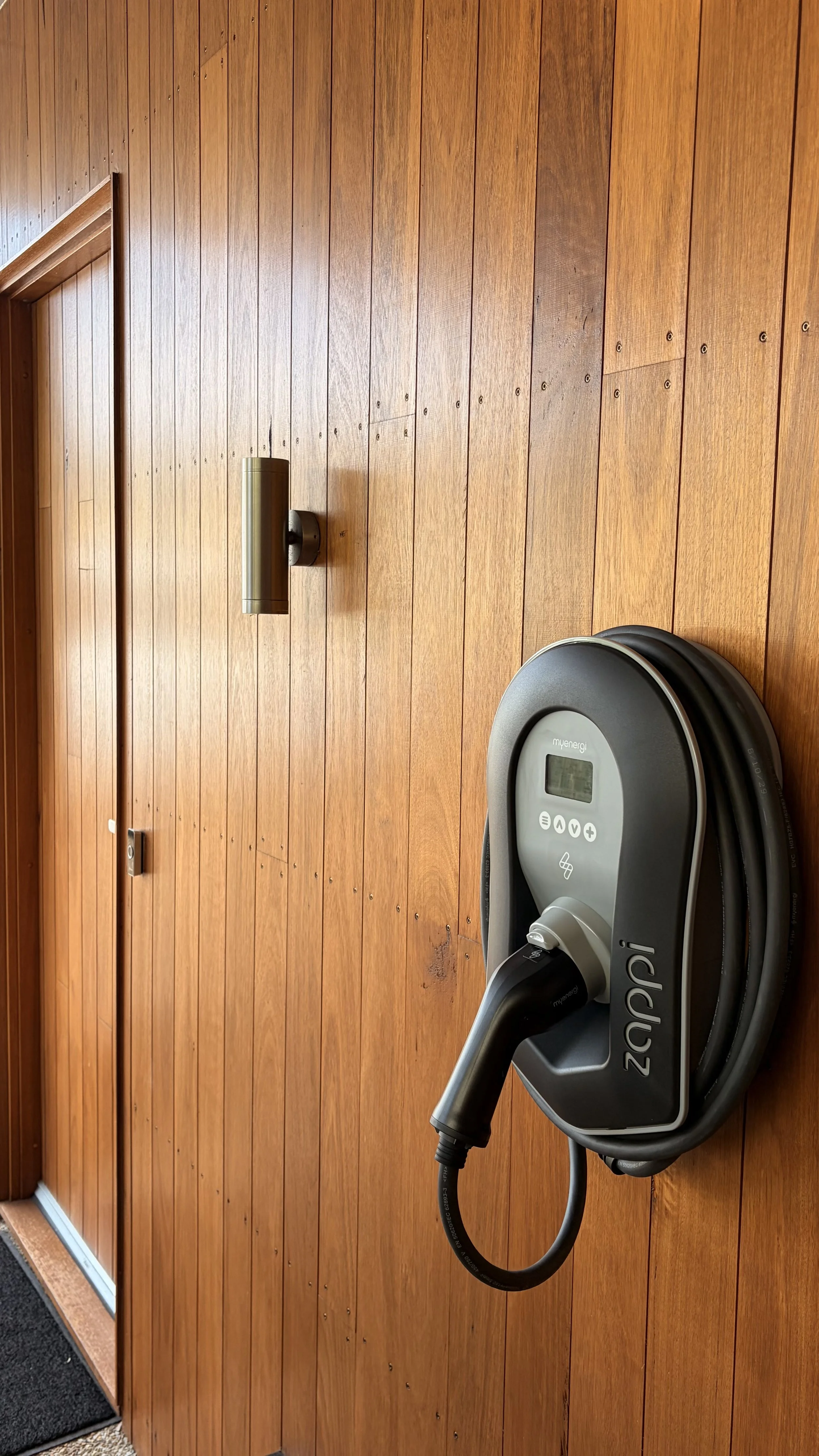 A myenergi Zappi EV charger installed indoors on a timber panelled wall of a passive home in Dromana.