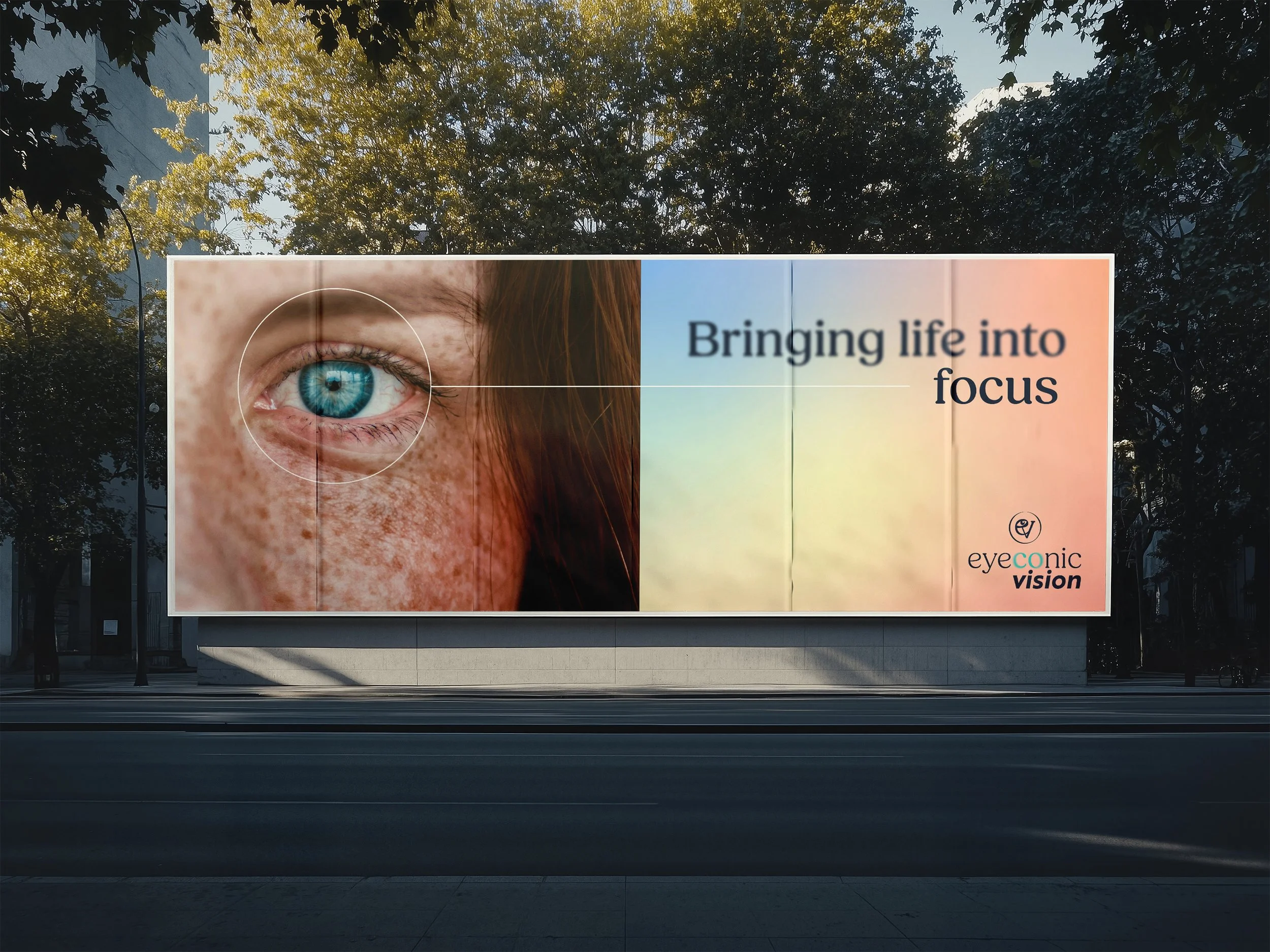 Large outdoor billboard advertising Eyeconic Vision with a close-up of a blue eye and woman with freckles, accompanied by the slogan 'Bringing life into focus.'