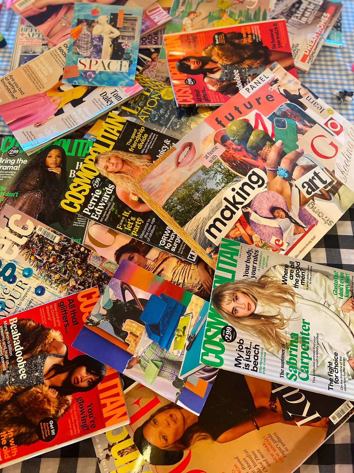 A pile of various magazine covers featuring celebrities, fashion, lifestyle, and entertainment topics. The magazines include topics like future art, space, breakup tips, and celebrity interviews.