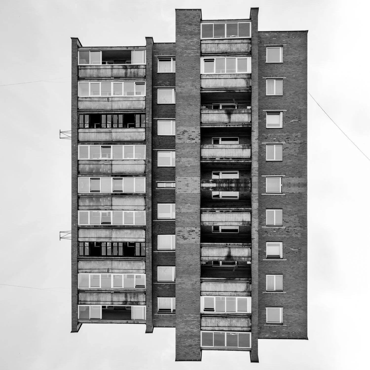 Black and white photo of a multi-story residential building with balconies.