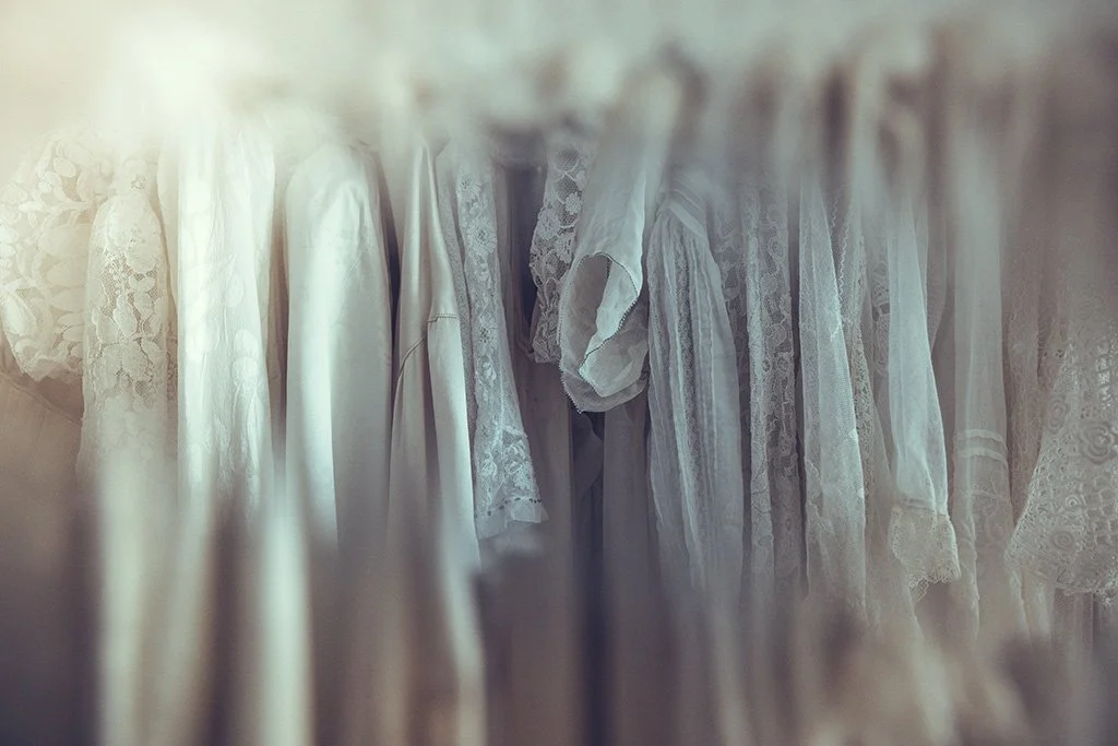 Hanging white and lace vintage and pre-loved  Tuesday's Bride wedding dresses.