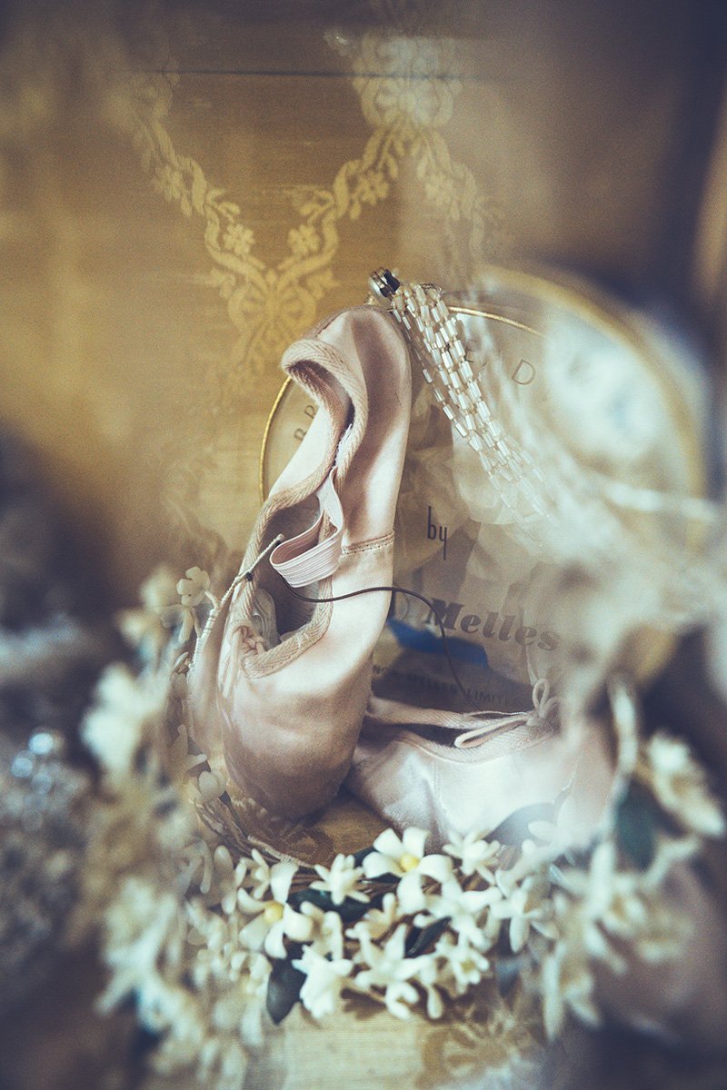 Vintage Wedding slippers, a necklace, and a flower crown inside a decorative box with gold inner lining.