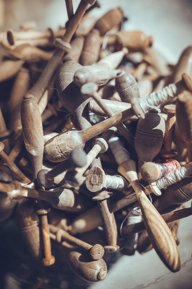 A pile of old wooden spools and bobbins.