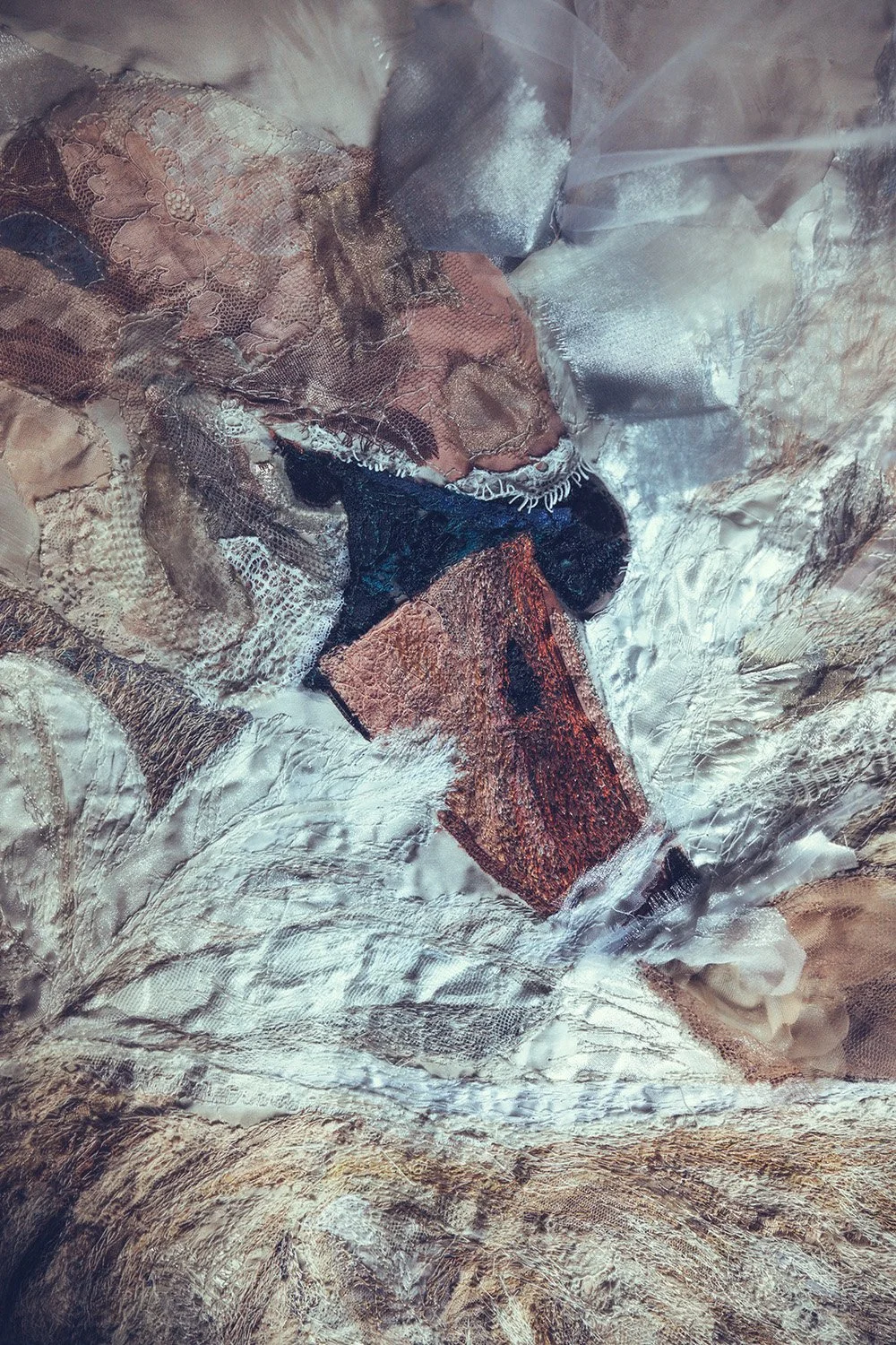 Close-up of various fabric and textile scraps, including lace, mesh, velvet, and burlap, arranged in a collage-like manner.