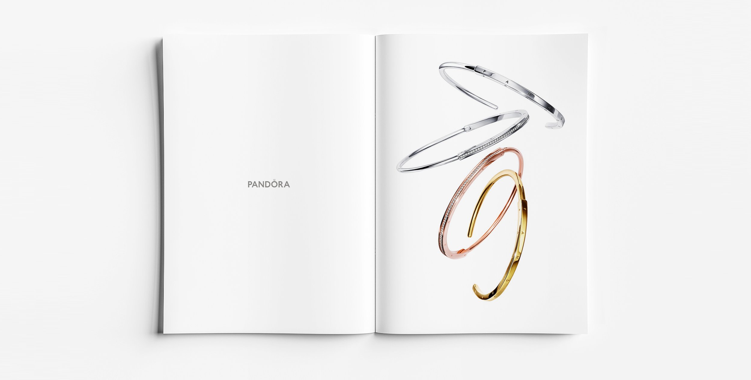 Pandora Signature iconic open bangle in silver, yellow gold and rose gold, minimalist logo jewellery design developed for Pandora by Myles Day Jewellery Artist.