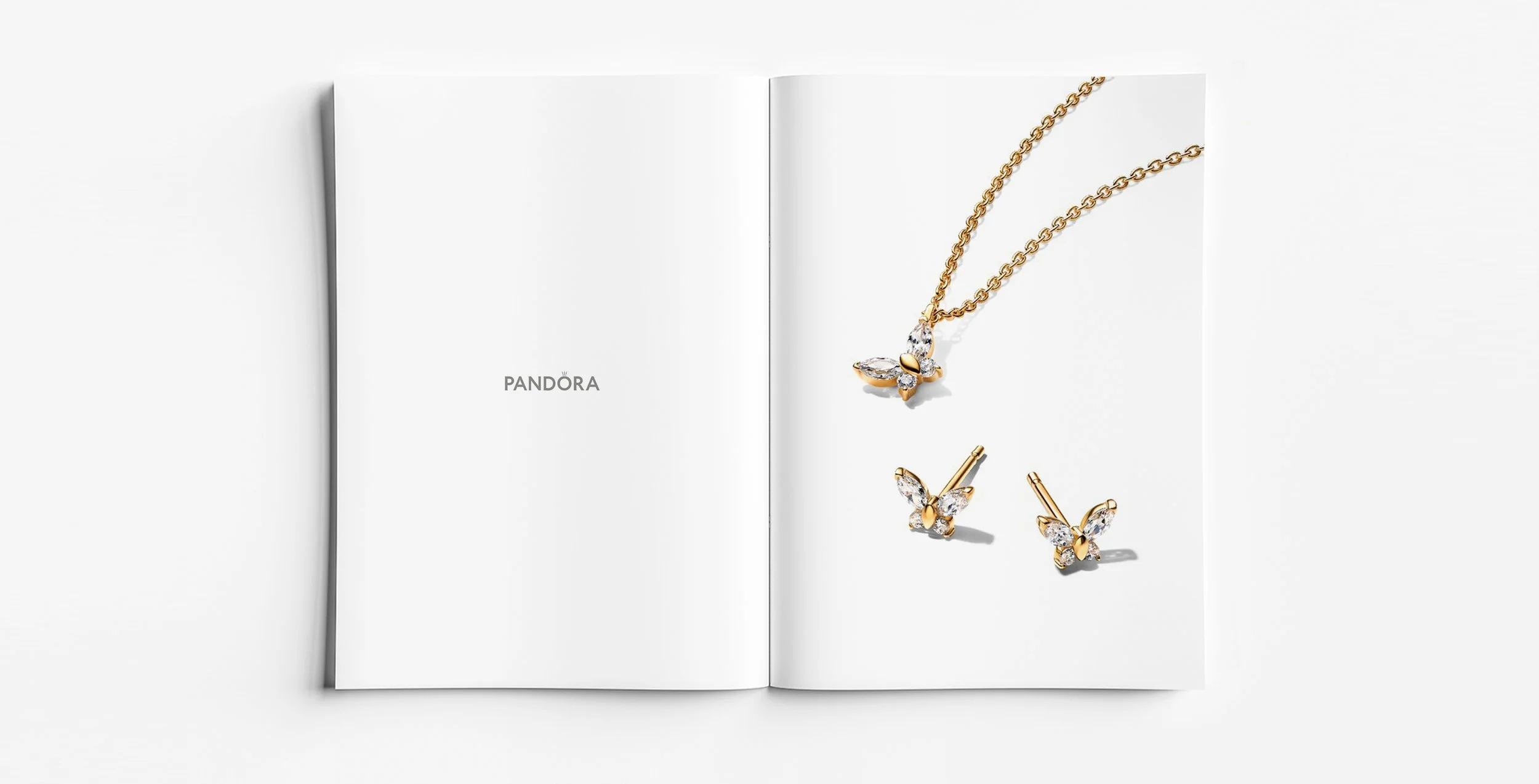 Pandora Timeless Collection butterfly motif pendant necklace and matching stud earrings in gold. Design by Myles Day Jewellery Artist.