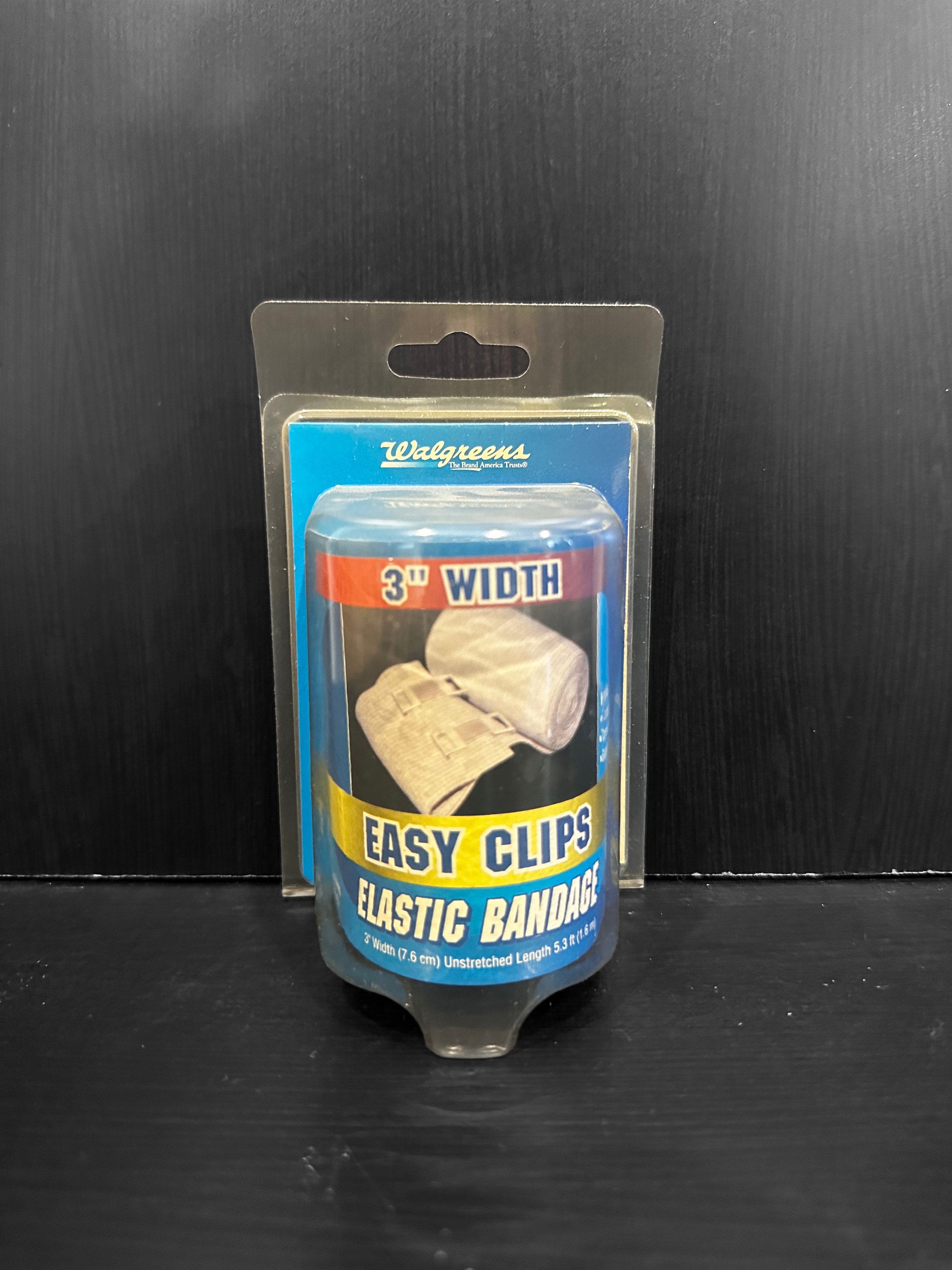 Landscape of a turquoise lake surrounded by green hills and mountains under a cloudy sky.