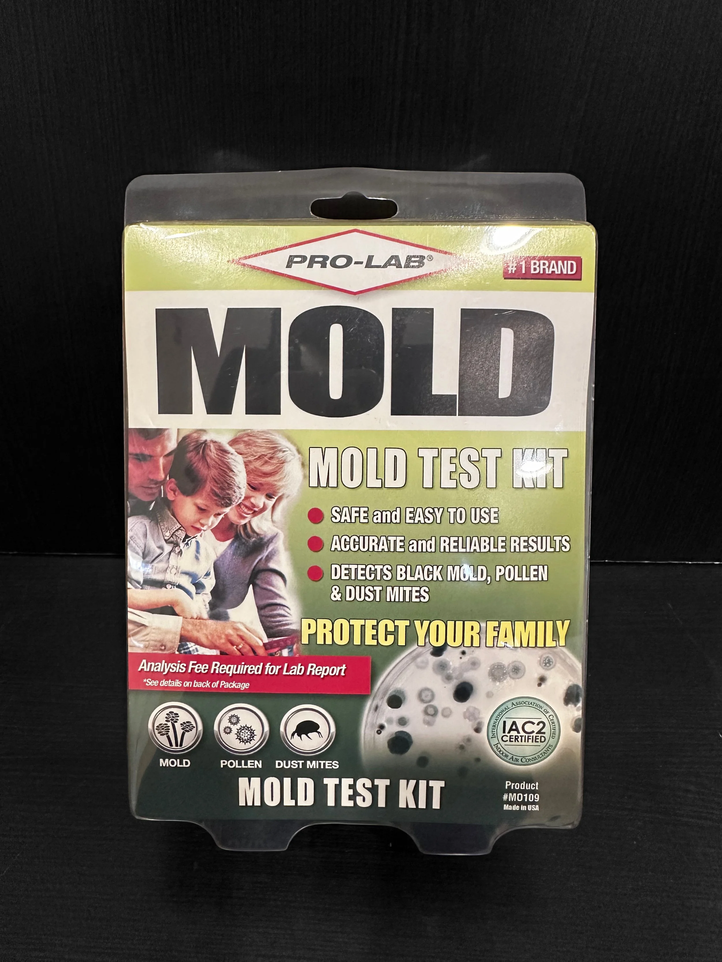 A small building on a grassy hill with snow-capped mountains in the background.