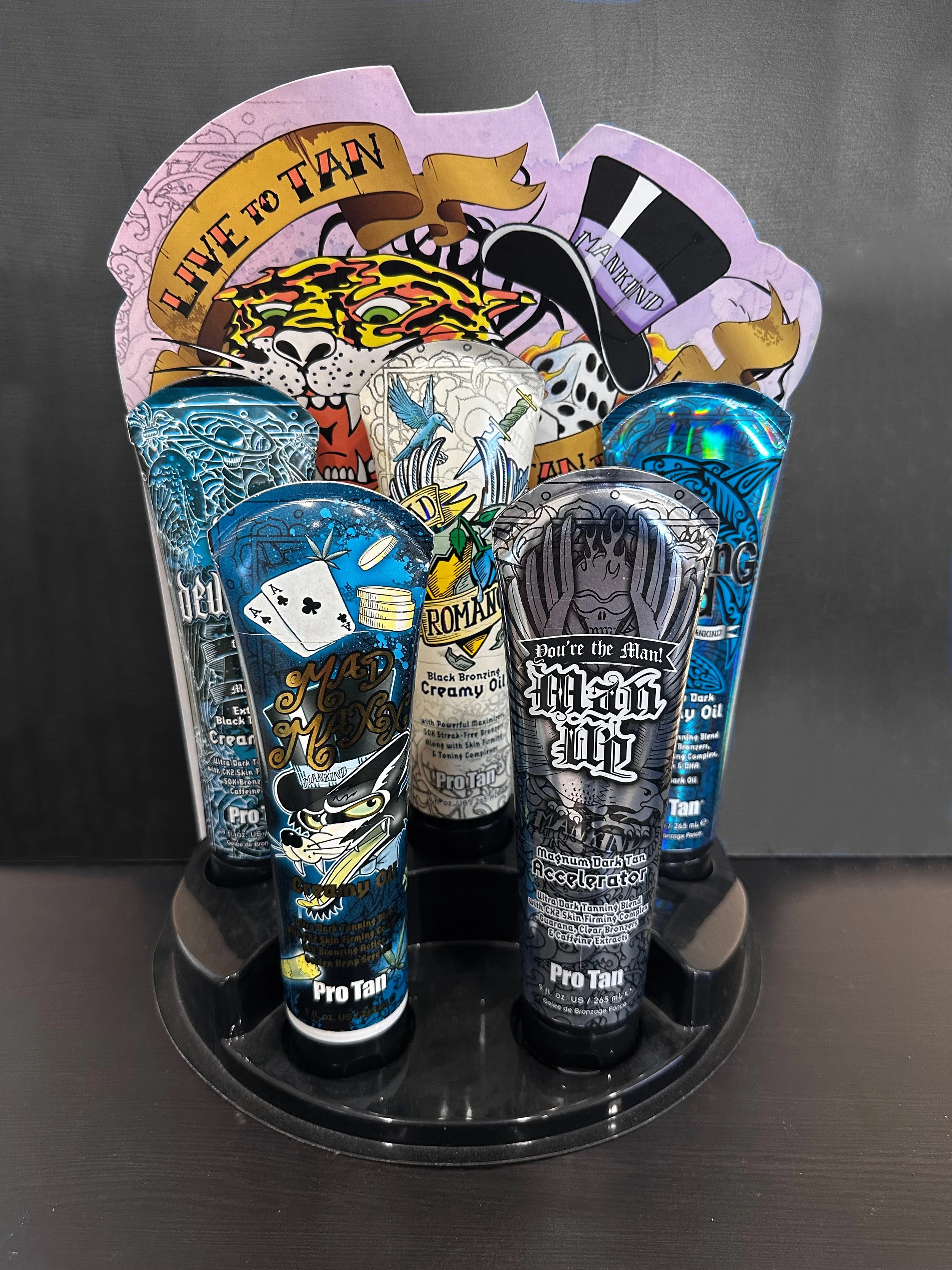 Scenic view of a turquoise lake surrounded by rolling hills and towering mountains under a cloudy sky.