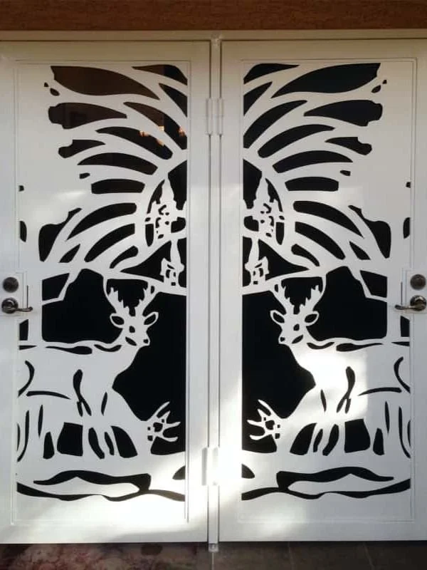 Decorative double doors with black and white silhouette art of two deer with large antlers.