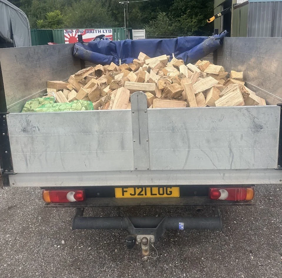 The back of a trailer filled with chopped firewood.