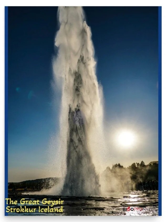 A rectangular museum quality poster print of the Great Geyser in Iceland spewing a column of steamy water and droplets skyward with the bright starburst sun in the blue sky behind, shimmering through the frothy water.