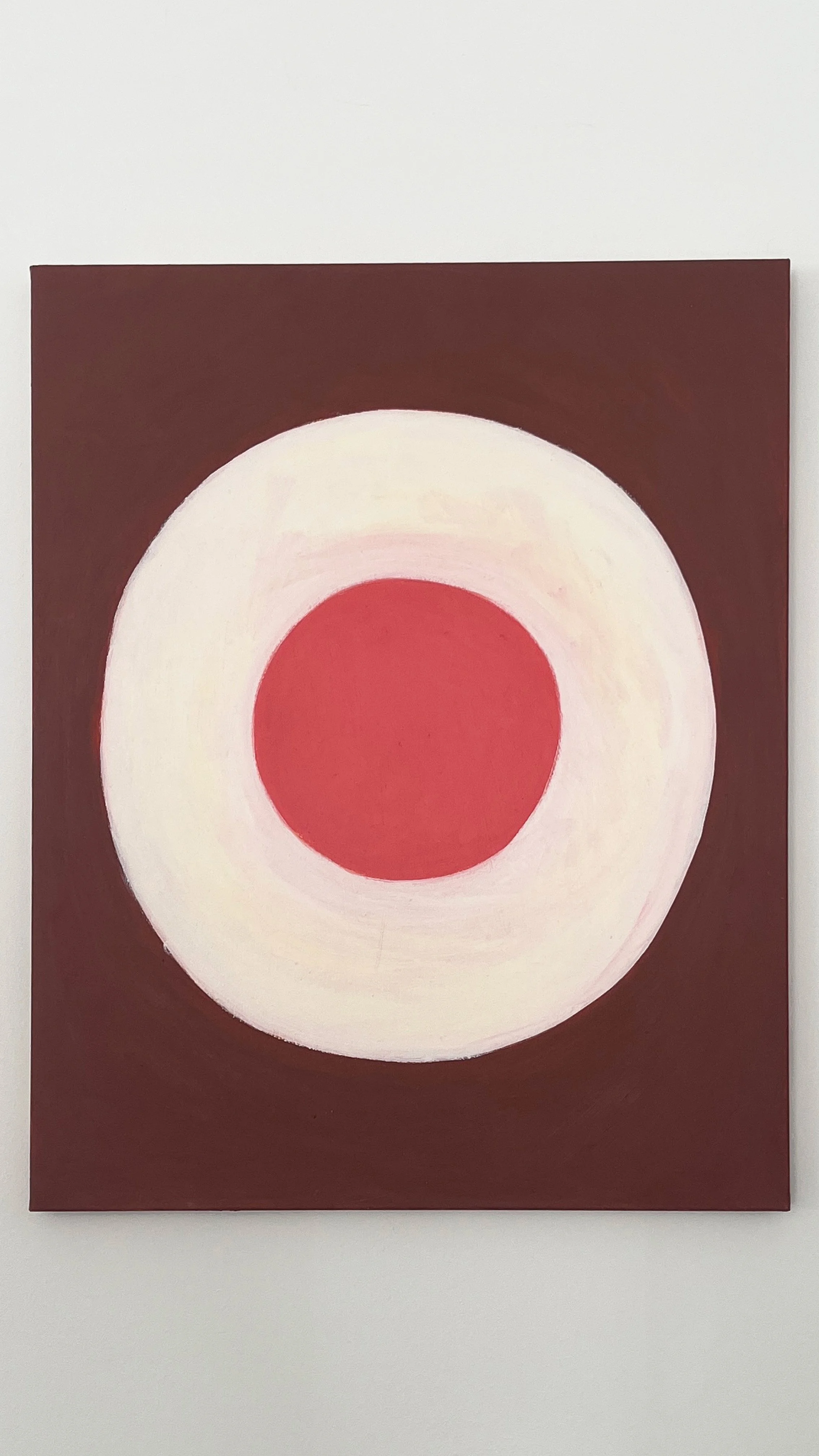 Abstract painting with concentric circles in red, white, and brown.