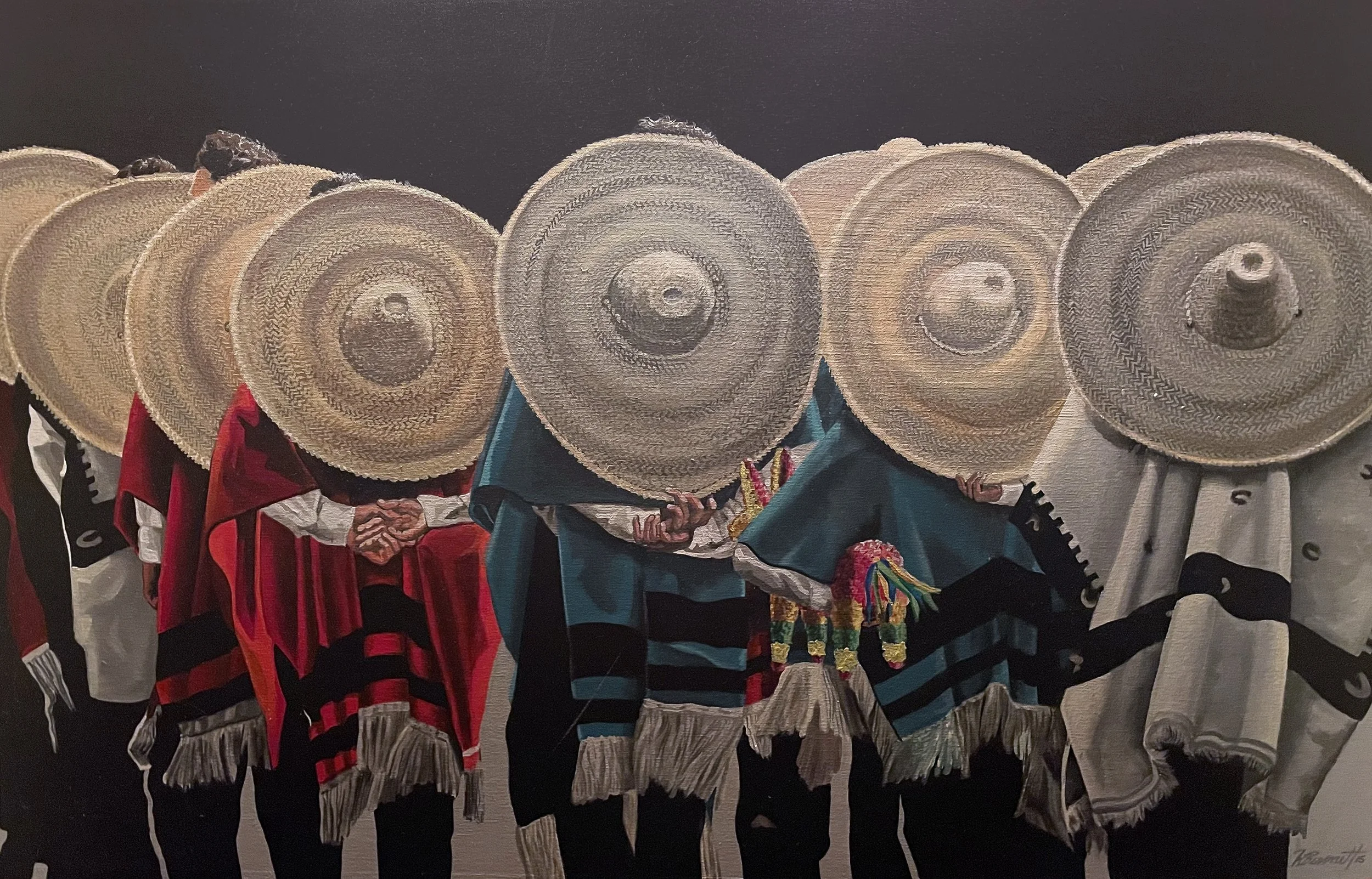 Group of performers wearing traditional Mexican charro outfits with large woven sombreros and colorful dresses, participating in a cultural dance or event.