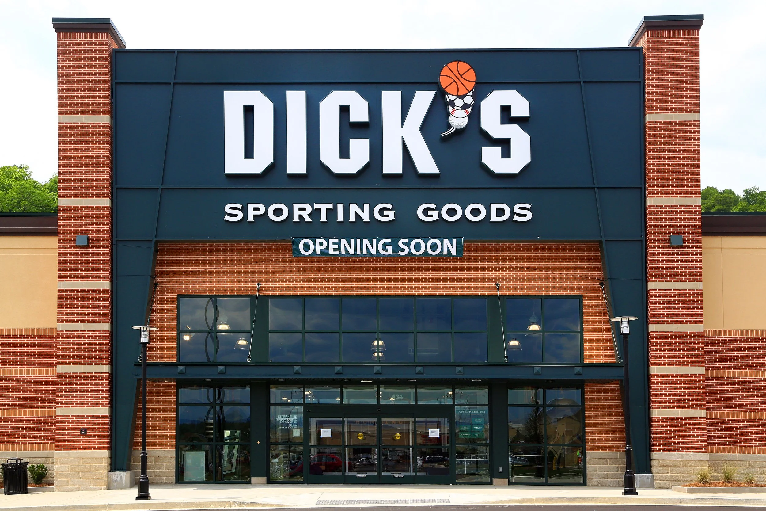 Storefront for DICK'S Sporting Goods with large sign showing a basketball, soccer ball, and baseball.