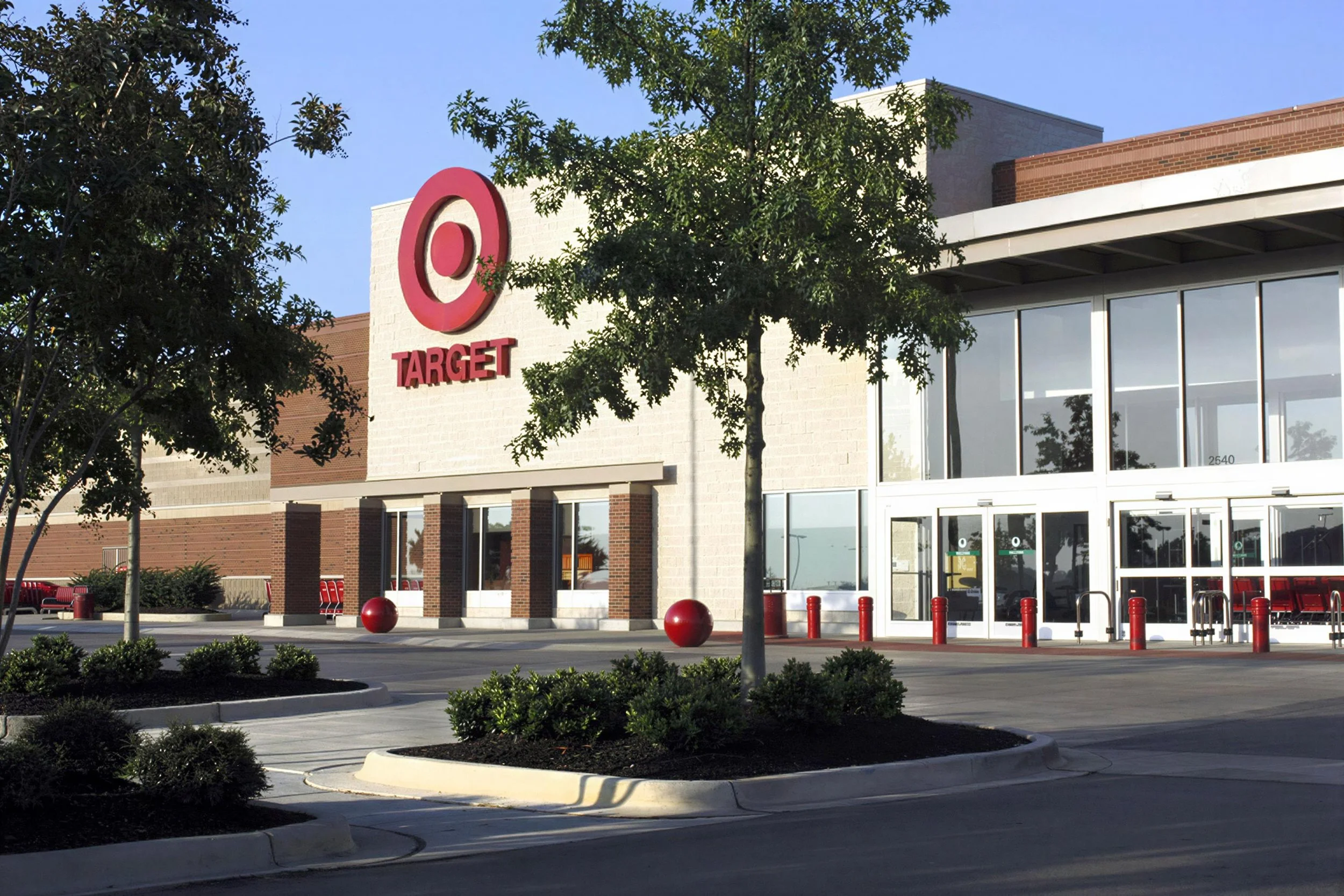 The exterior of a Target store with red and white branding, large windows, trees, and a parking lot.