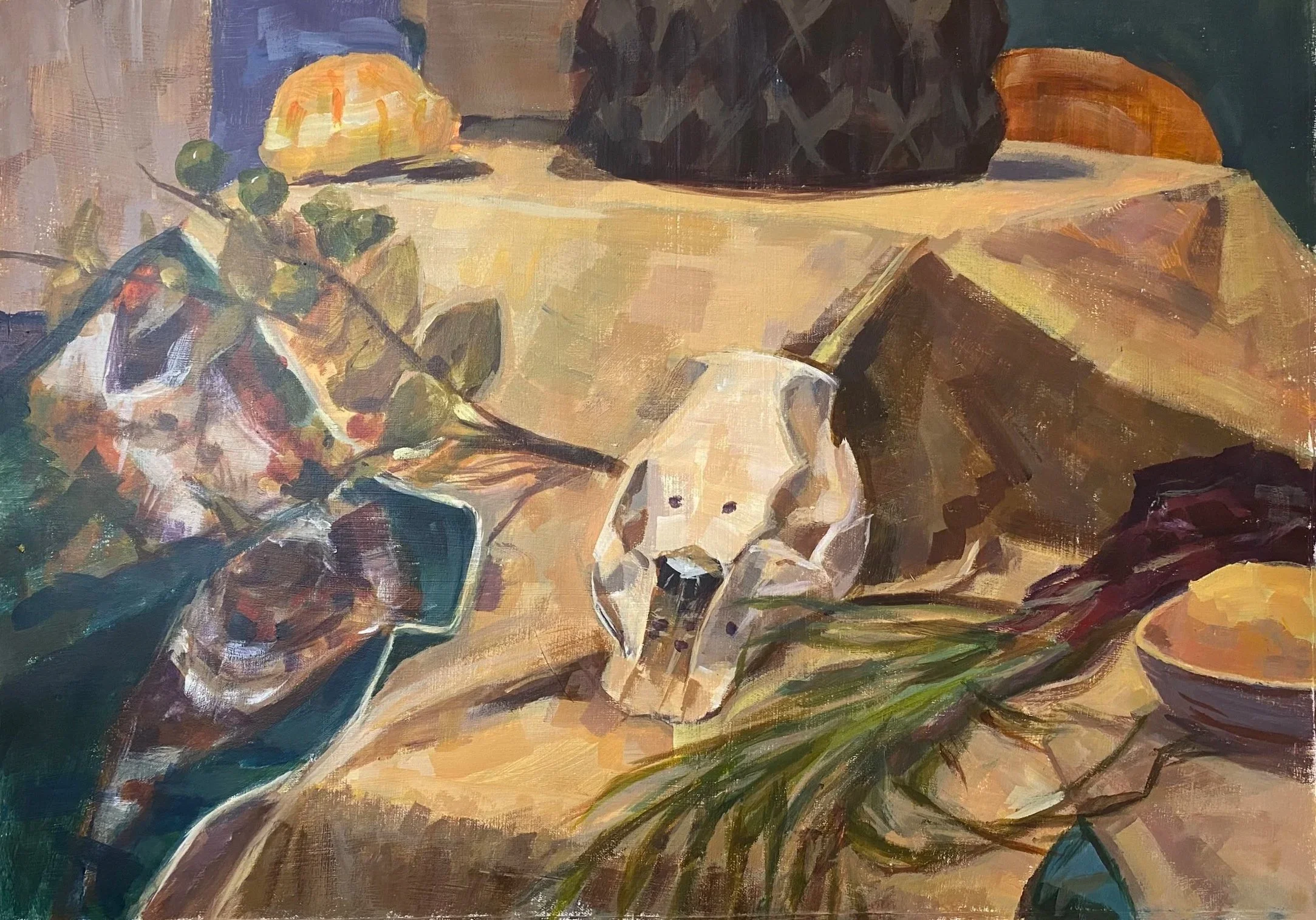 Still life painting of a table with a skull, green leaves, an orange, and a bowl. The table has a yellow tablecloth and dark background.