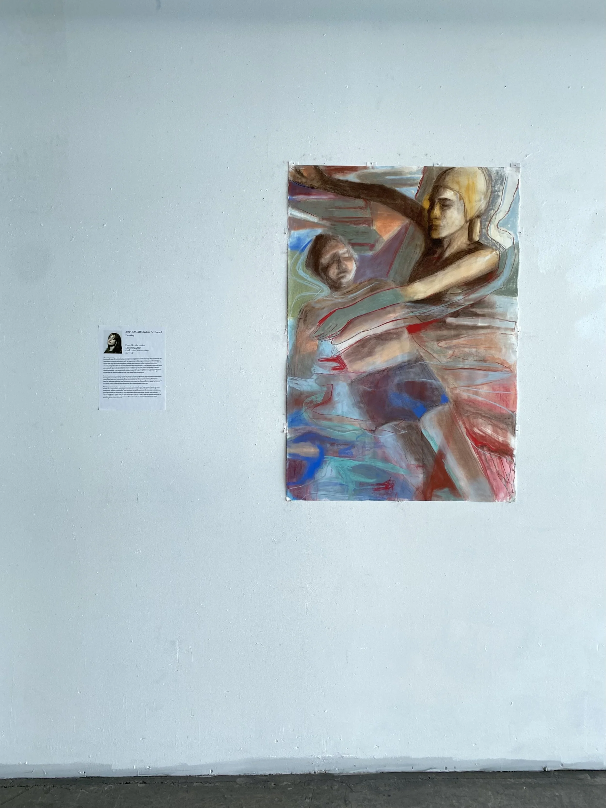 An abstract painting of two figures in water with one figure embracing the other, mounted on a white gallery wall.