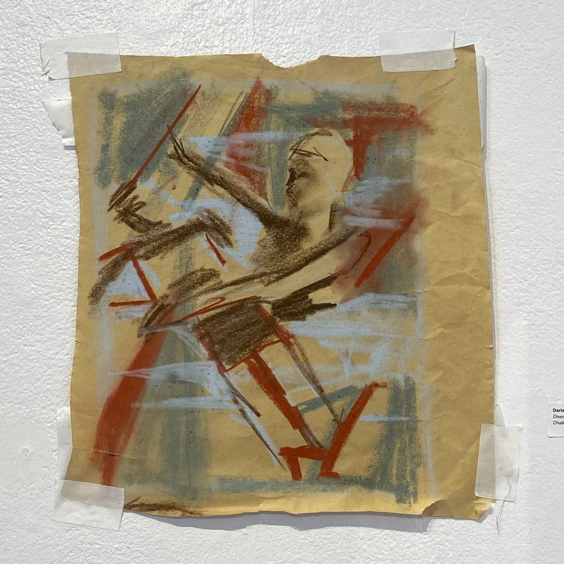 Abstract artwork of a reclining female figure with dynamic brushstrokes in red, black, white, and blue tones on textured, beige paper taped to a white wall.