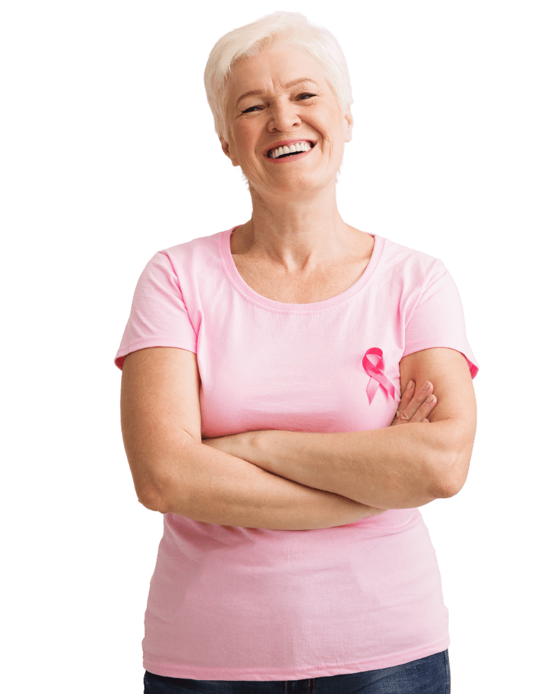 Vrolijke oude vrouw met korte witte haar, gekleed in een roze t-shirt met het roze lint dat symbool staat voor borstkanker, lachend en met armen gekruist.