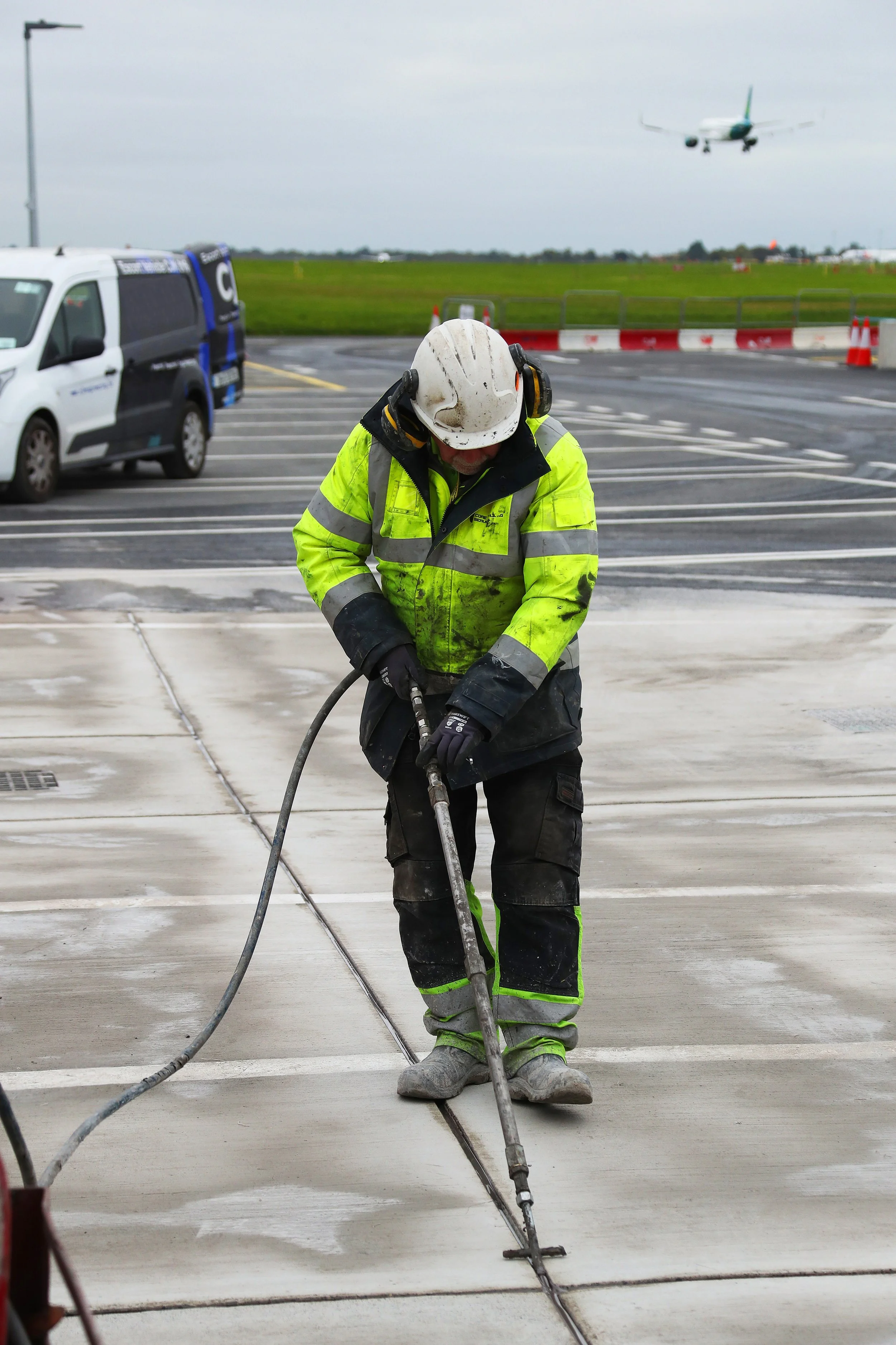 Cold applied joint sealant works underway in airfield environment on new PQ concrete.
