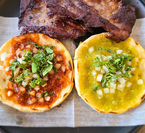 Bacon, two mini pizzas with toppings, cilantro, diced onions, and cheese.