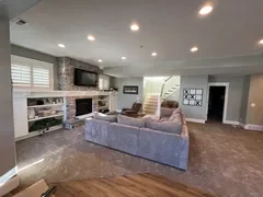 After: Stunning open-concept living room with stone fireplace, built-in shelves and luxury sectional – Ogden, Utah whole-home remodel by VCON Remodeling & Restoration