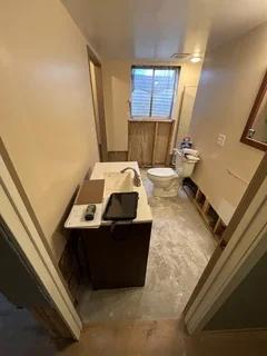 Before: Water-damaged basement bathroom with old and ruined fixtures in Clearfield, Utah – ready for complete rebuild by VCON Remodeling & Restoration