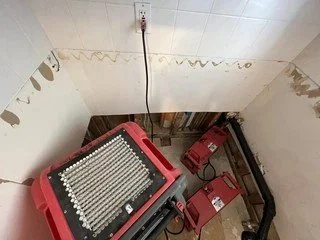 During: Water-damaged bathroom in Brigham City, Utah with professional dehumidifiers and air movers drying walls after flood – emergency mitigation by VCON Remodeling & Restoration partners