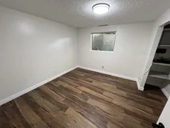 After: Finished basement bedroom with luxury vinyl plank flooring and new baseboard– Clearfield, Utah remodel by VCON Remodeling & Restoration