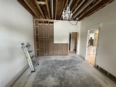 Before: Bedroom during water damage 
demolition with exposed ceiling, ductwork, and removed walls – Ogden, UT before whole-home remodel by VCON