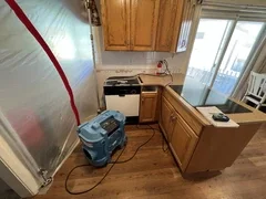 Before: Kitchen under full containment with professional drying equipment after major leak – Brigham City, UT - VCON Remodeling & Restoration