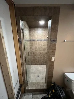 Before: Outdated basement bathroom shower with glass door and damaged surround during demo – Harrisville, UT before complete rebuild by VCON