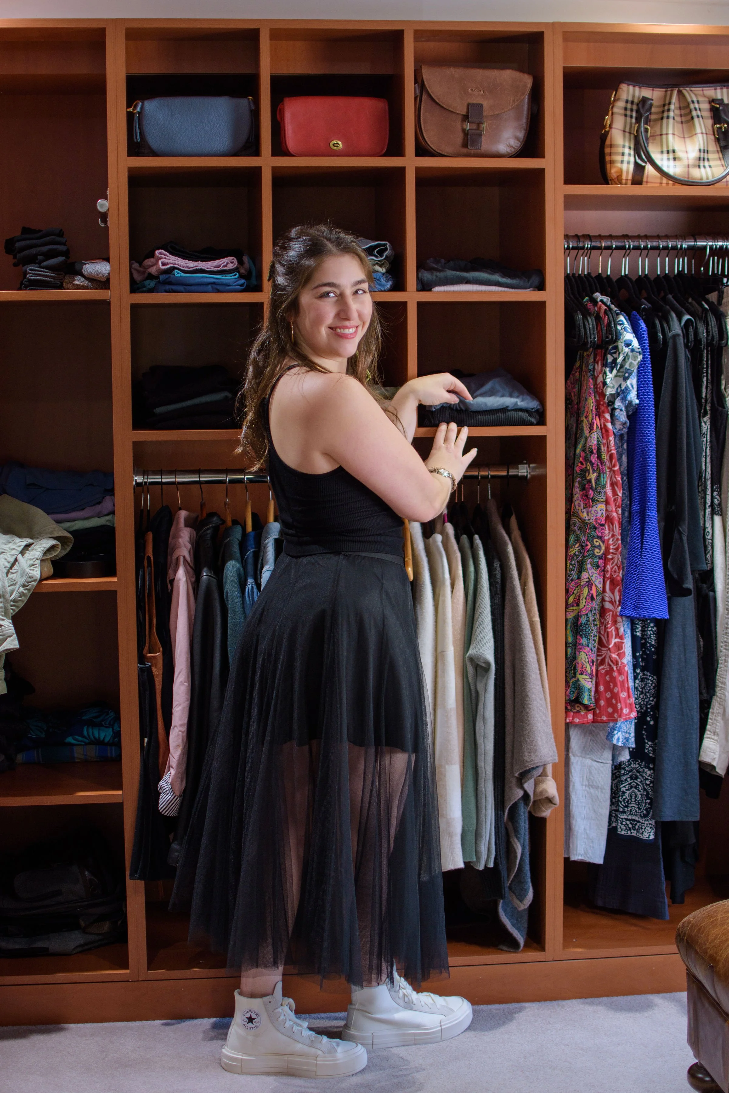 Professional organizer inside walk-in clothing closet