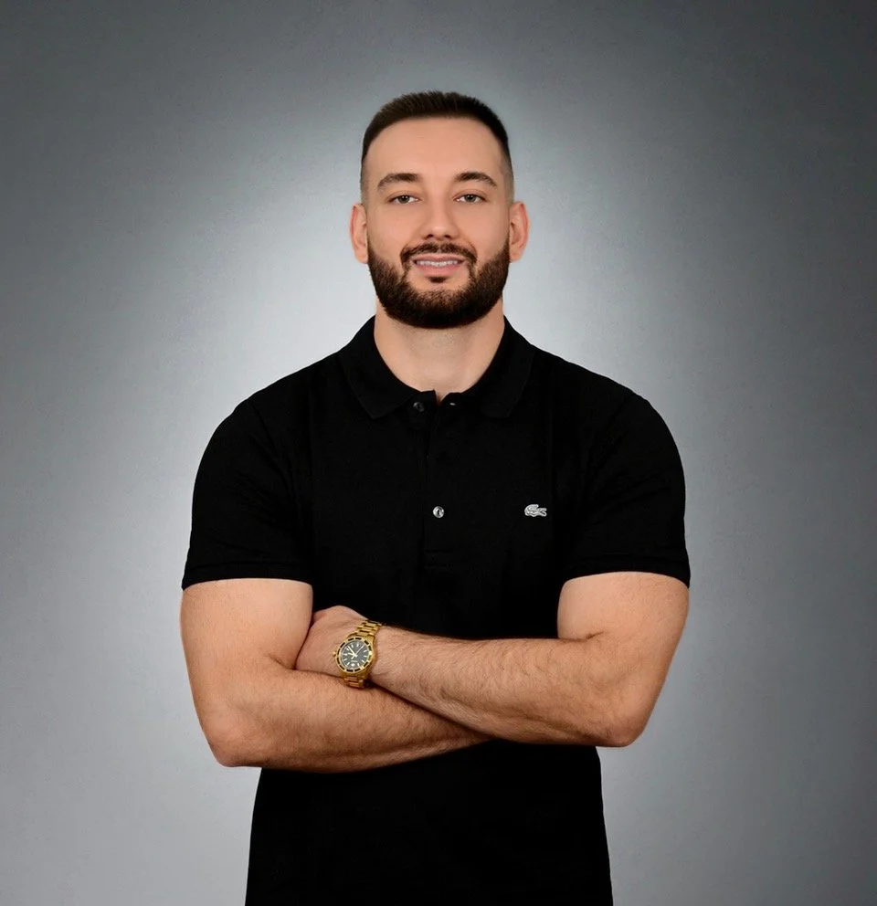"Arman Sepahdoost, Chiropractor in Mississauga, smiling in his clinic uniform."
