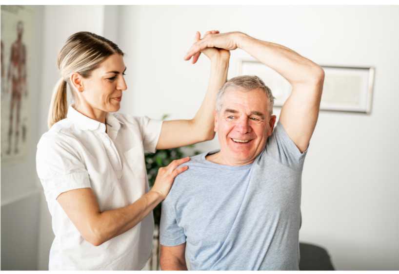 A physical therapist-Yakshi-Rajpura helping a senior man stretch his arm during therapy session Health-mantra-Physiotherapy-mississauga